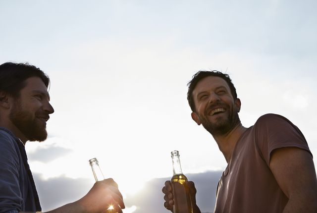 Men holding beers and laughing
