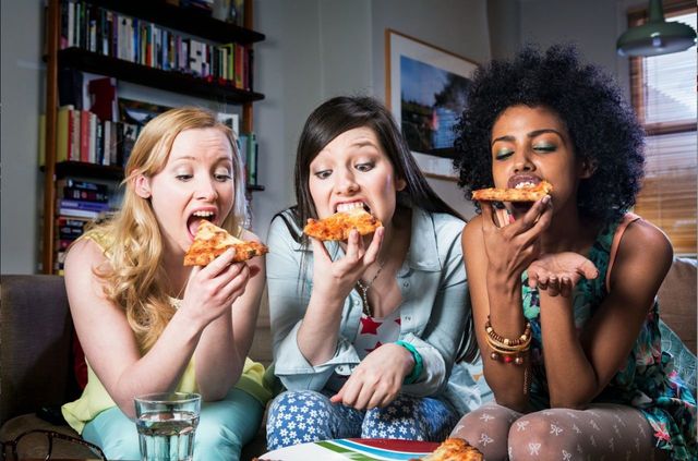 girls women eating pizza night in unhealthy diet