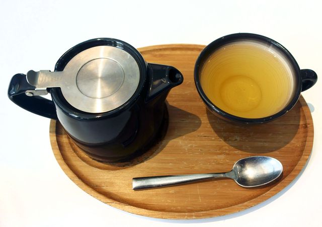 Cup of tea with teapot on tray