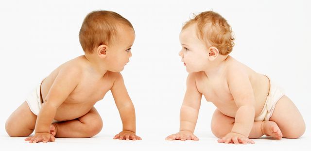 Two crawling babies, looking at each other