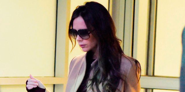 Victoria Beckham at the airport wearing a camel coat