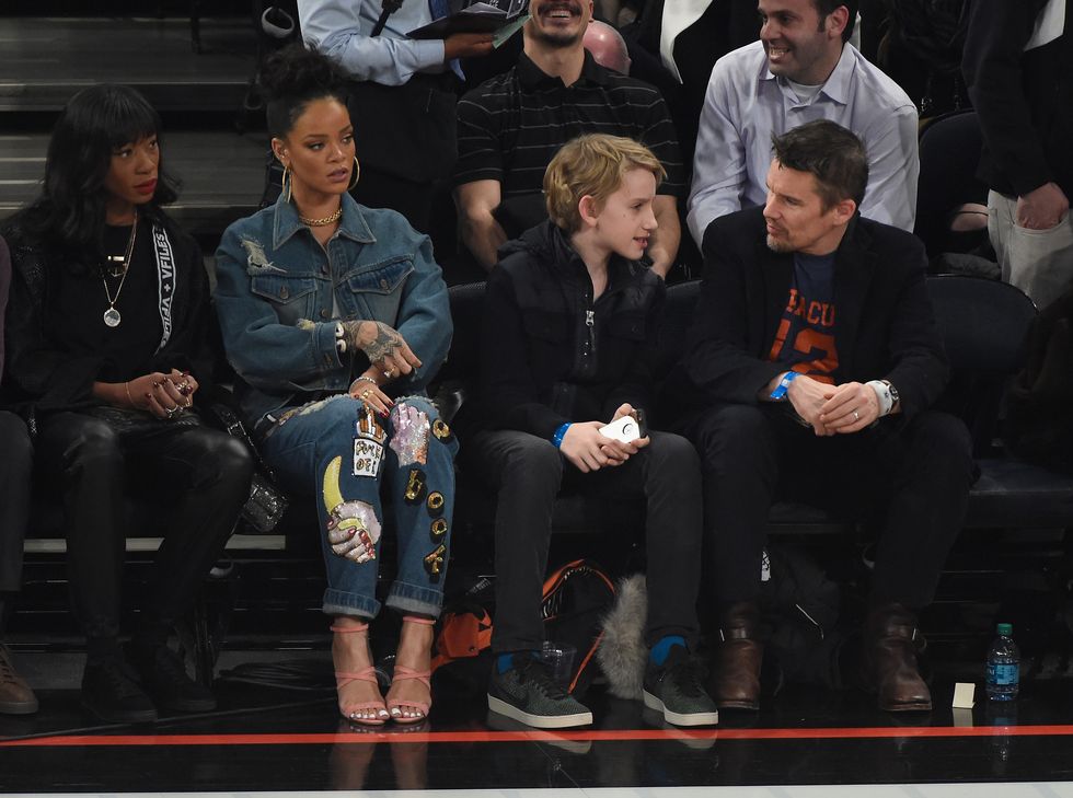 Rihanna at the basketball wearing denim jeans and jacket