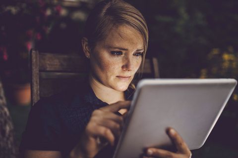 Woman looking sad with tablet outside