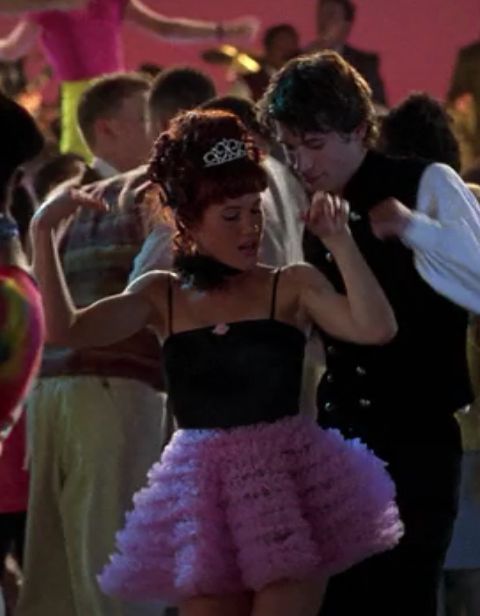 Amber from Clueless wearing a pink skirt at a party