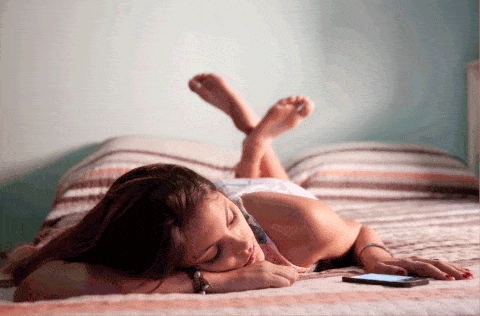 woman on bed with phone