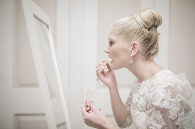 Bride applying make-up before wedding