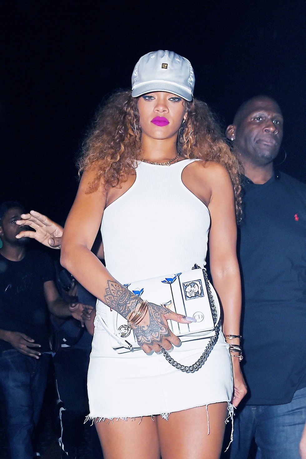 Rihanna wears bright pink lipstick with a white dress and baseball cap to hit the club with Lewis Hamilton