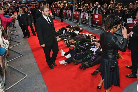 Domestic violence campaigners lie down on the red carpet at the London British Film Festival premiere of Suffragette in protest of government cuts