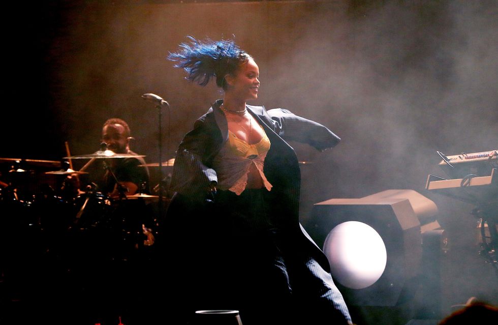 Rihanna flying through the air with a blue ponytail