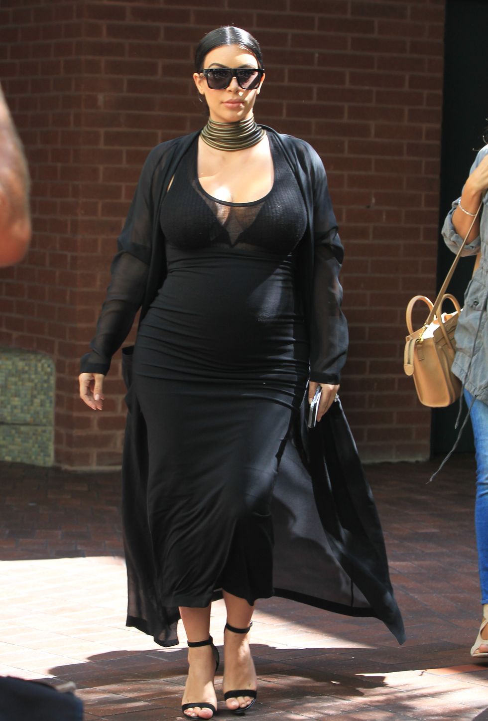 Kim Kardashian wearing a black dress and gold necklace