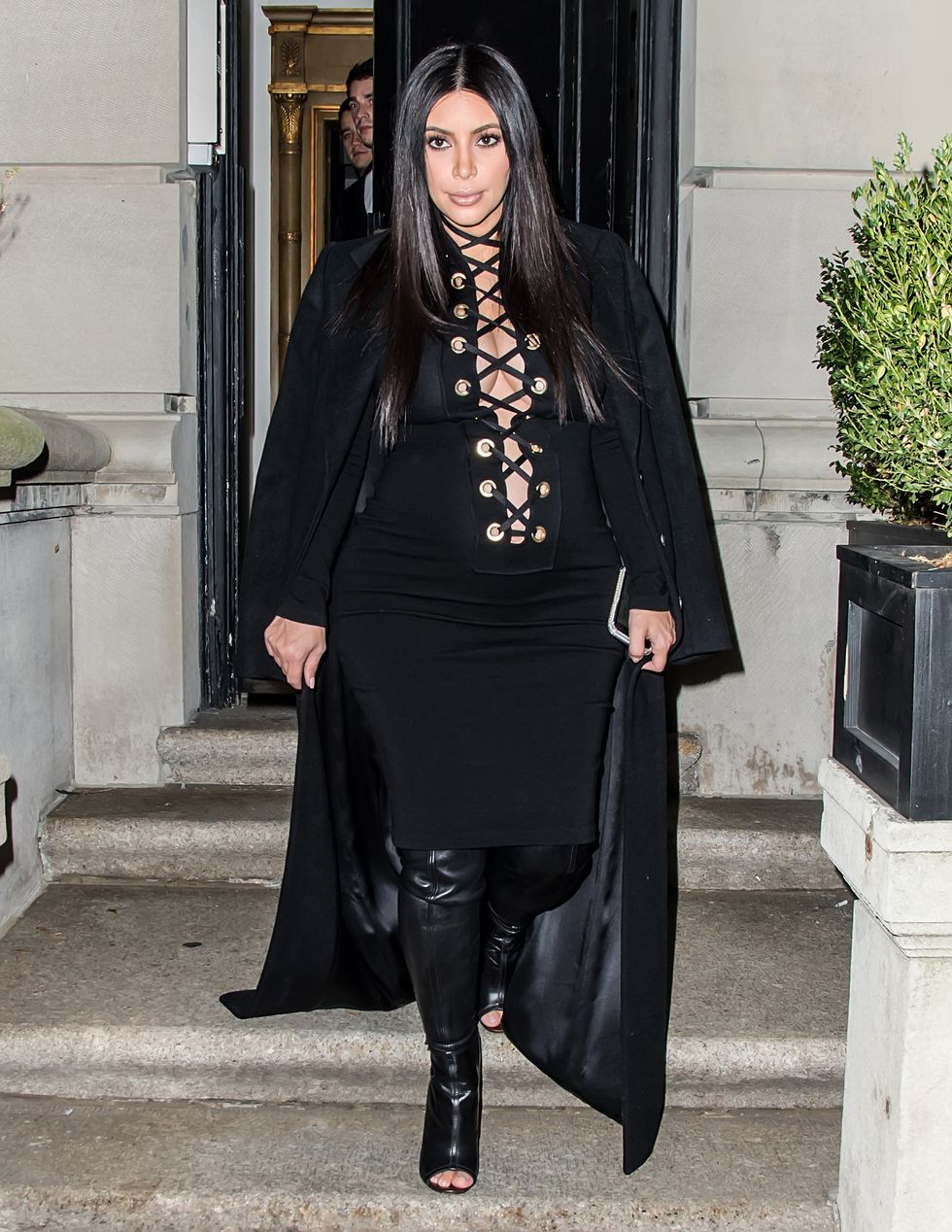 Kim Kardashian wearing a black lace up dress and boots