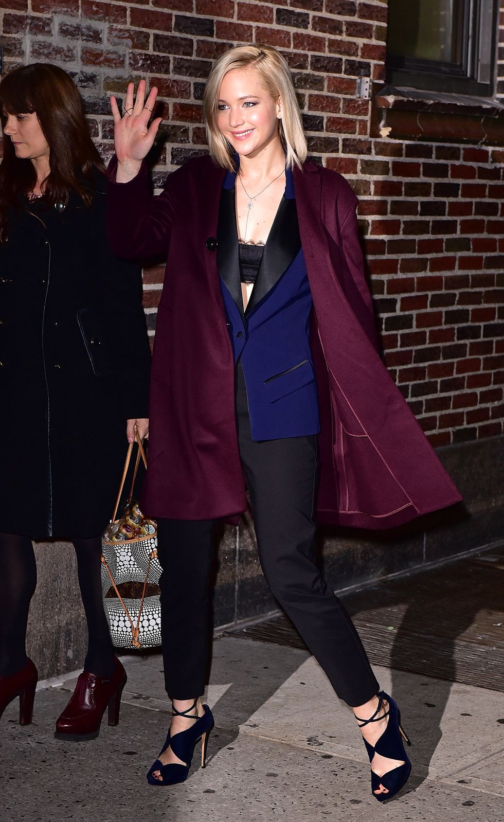 Jennifer Lawrence wearing a blue tux and plum coat