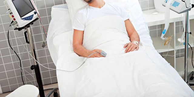 man lying in hospital bed