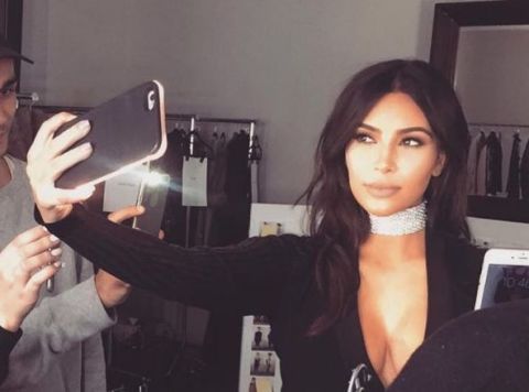 Kim Kardashian taking a selfie with her light up phone case