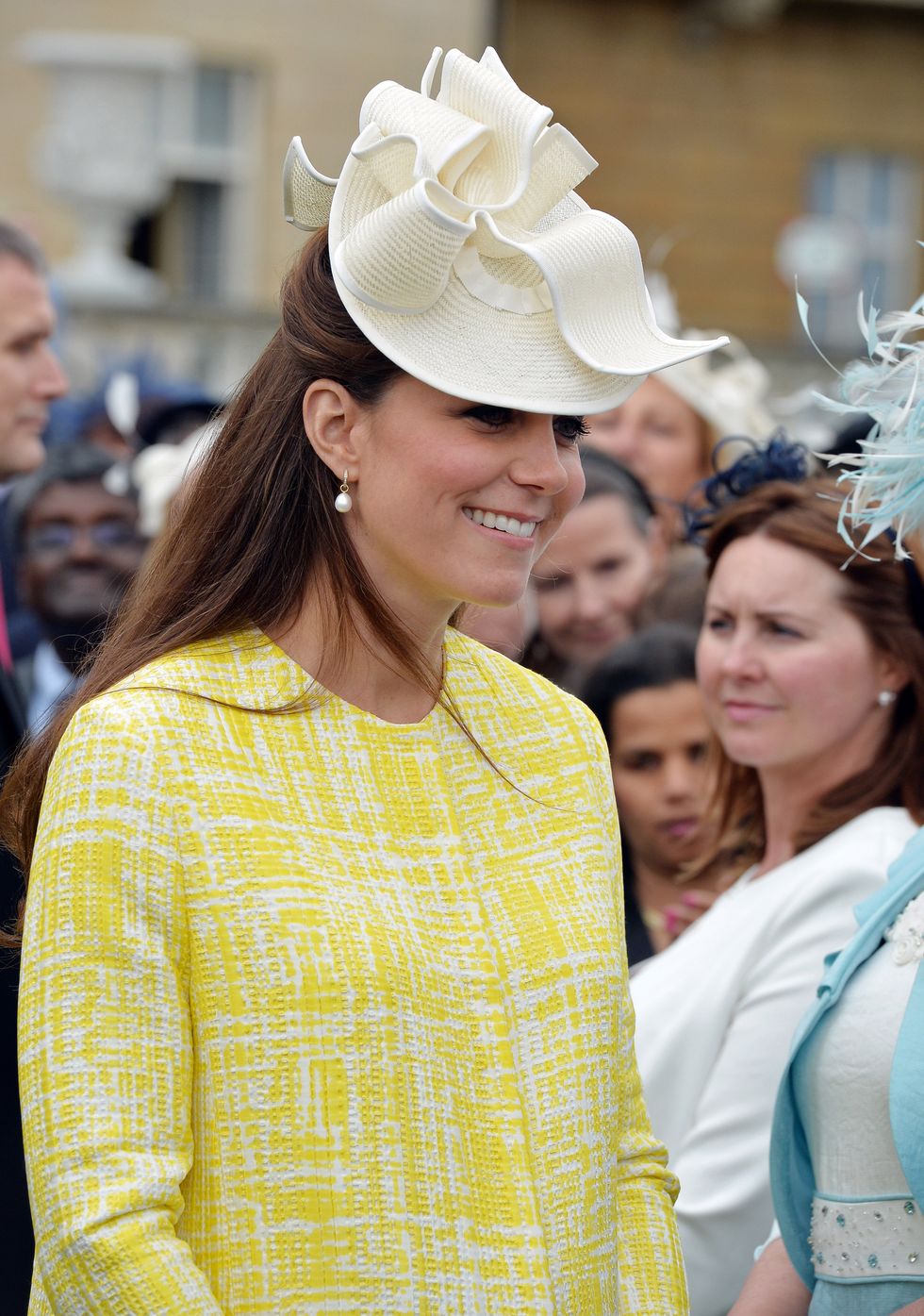 Kate Middleton wearing a yellow coat and pearl drop earrings