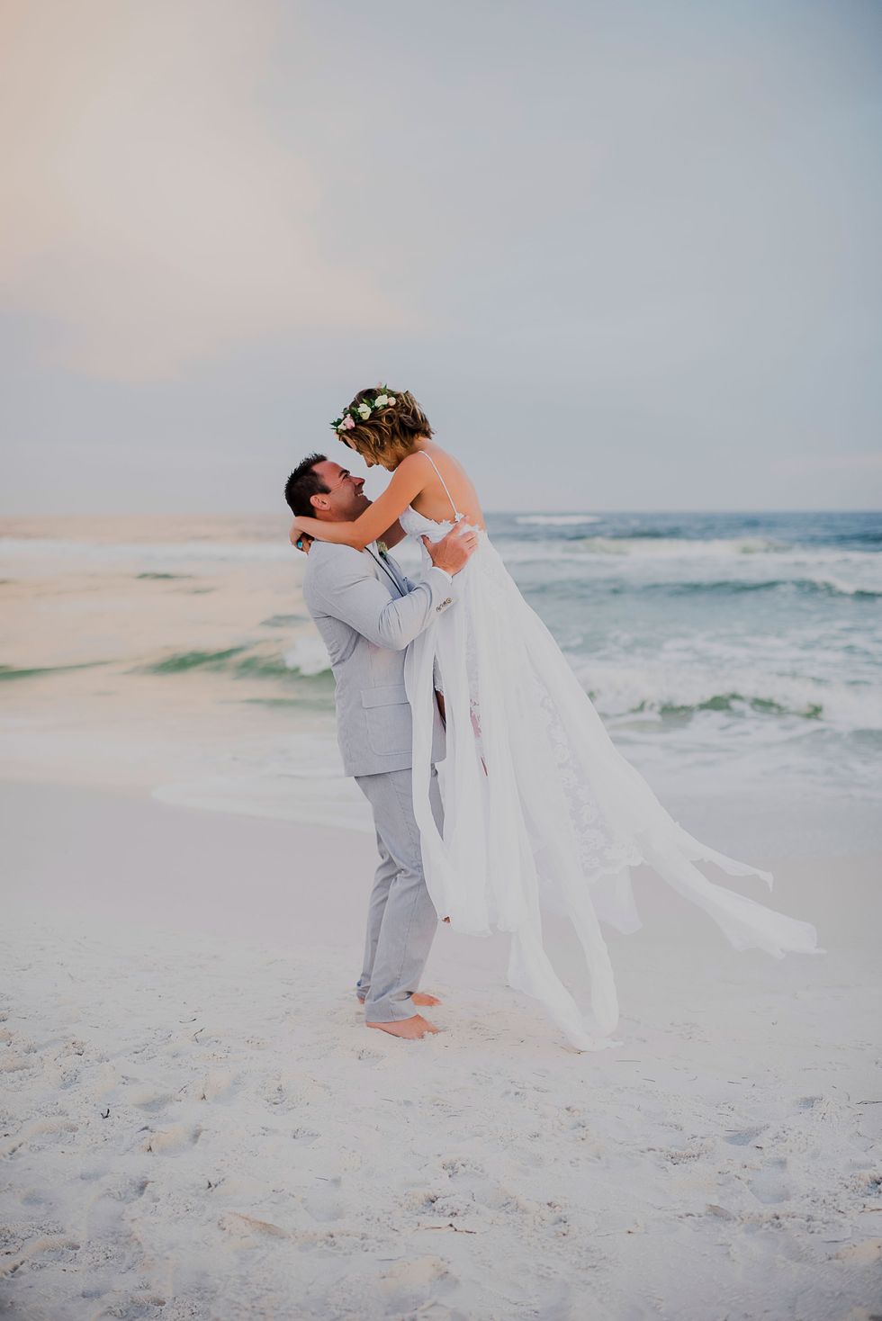 Bridal clothing, Dress, People on beach, Textile, Photograph, Bride, Standing, Happy, Wedding dress, Bridal veil, 