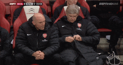 Arsene Wenger struggling to do up coat zip
