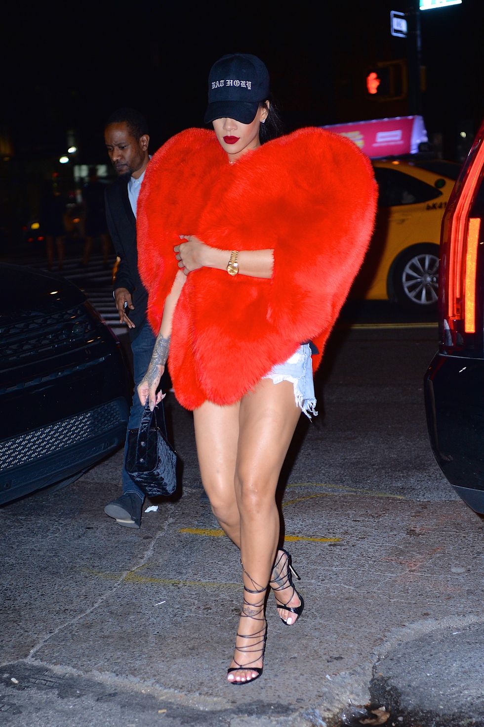 Rihanna wearing a red fox fur cape