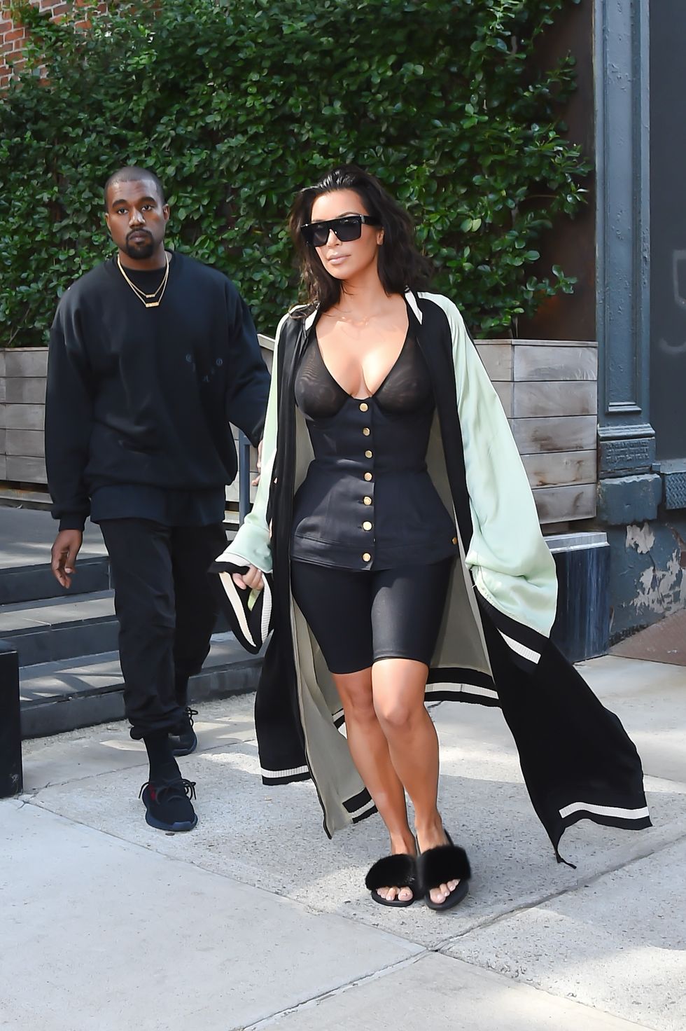 Kim Kardashian West wearing cycling shorts and furry slides