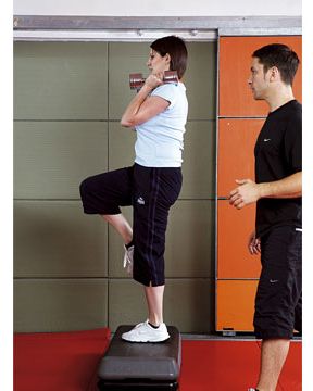 Start with feet shoulder-width apart, chest and head up, a weight in each hand at shoulder height. Step up with your right leg, raising your left leg above waist height. As you do, push the weights above your head. Return your left foot to the floor and arms to shoulder height then switch legs.<br />