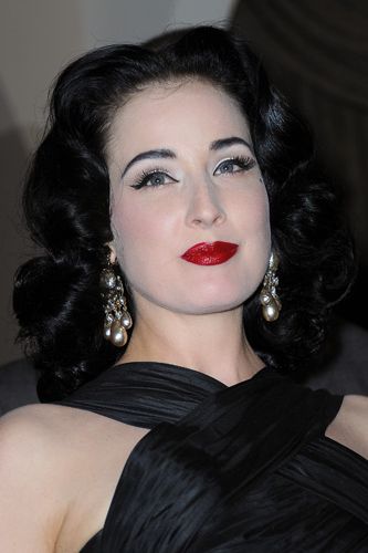 Whiter-than-white skin, jet black brows, lashings of liner and blood red lips. Dita Von Teese could have come straight from the set of a Dracula film.
