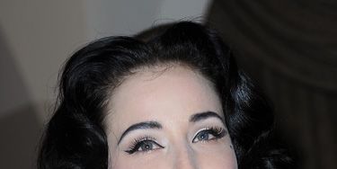 Whiter-than-white skin, jet black brows, lashings of liner and blood red lips. Dita Von Teese could have come straight from the set of a Dracula film.
