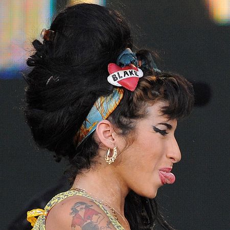 <p>Amy wore her heart on her headscarf to keep her trademark beehive in place</p>