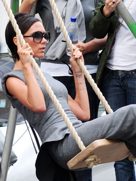 Posh had a go on a swing after filming an advert for her latest collection of dresses. We're surprised she could move in this grey, tight-fitting frock from her own range...<br /><br />