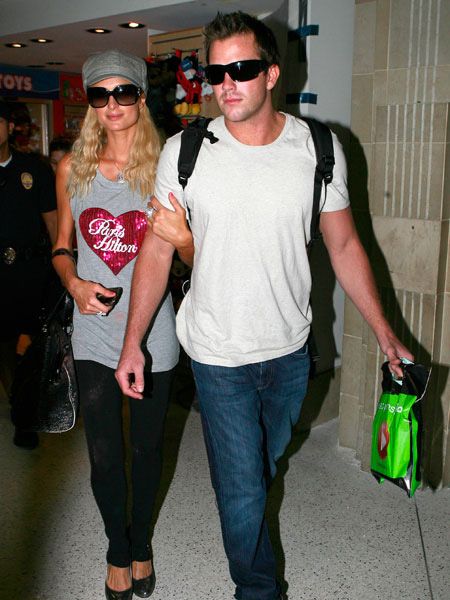 The ever modest Paris Hilton was spotted arriving at LAX with her name emblazoned across her t-shirt. And it seems the heiress is very much back on again with boyfriend Doug Reinhardt...