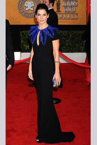 <p>Sandra looked super sophisticated in a black gown with blue sequin feather detailing by Alexander McQueen, accessorised with a chic silver box bag</p>