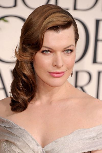 <p>Channelling 1940s waves, Milla Jovovich swept her hair to one side in a cleverly constructed mass of neatly coiffed curls. Wearing smoky brown eyeshadow and a rosehip lip to add to the old school glamour, she looks a picture of perfection</p>