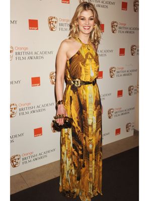 Rosamund Pike brightened up the rainy red carpet with her yellow printed halterneck gown by Alexander McQueen. Pulling her outfit in with a gold buckle belt and clutching a McQueen bag, we love Rosamund's sunny disposition