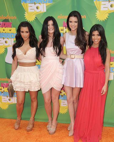 <p>Kim, Kylie and Kendall went for short frocks in pale shades whilst Kourtney opted for a hot-hued maxi dress, and all wore their dark locks long and loose</p>