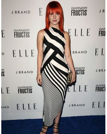<p>Hayley goes for a more mature look in this stripy monochrome dress at Elle's Women in Music event this year. We love her leopard print clutch</p>