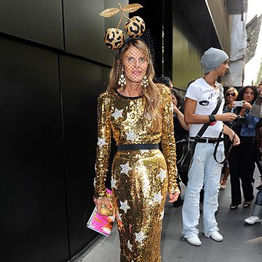 Anna Dello Russo arrives in style at the Dolce & Gabbana fashion show. We have to say, we love her dress - it's got us all starry eyed! We'd probably leave the cherry headgear at home though