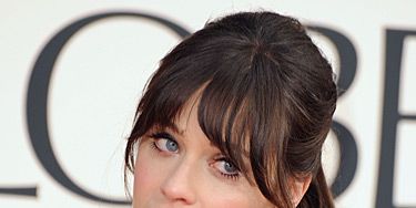 <p>We love Zooey Deschanel's fun and flirty red carpet beauty look. She showed up at the 2013 Golden Globe Awards with her hair tied up into a loose ponytail and curled the ends. She left out her full fringe and finished off the look with matte red lips.</p>
<p>Oh, and did you catch her black-and-white glitter <a href="http://www.cosmopolitan.co.uk/beauty-hair/news/beauty-news/zooey-deschanel-wears-film-strip-nail-art-at-2013-golden-globe-awards" target="_blank">camera and film strip nail art</a>? FAB!</p>