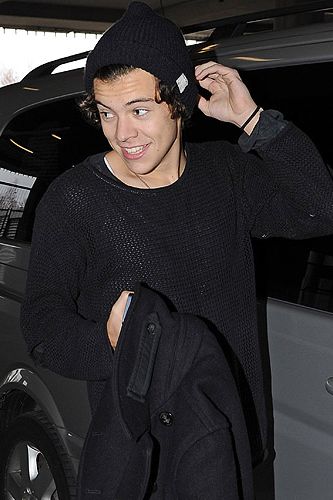 <p>Cute! Harry Styles landed in at Heathrow airport looking adorable in a hat (he loves a beanie!) and a black jumper. But it's the face, just look at the grin on his face.</p>