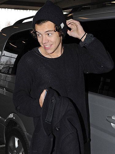 <p>Cute! Harry Styles landed in at Heathrow airport looking adorable in a hat (he loves a beanie!) and a black jumper. But it's the face, just look at the grin on his face.</p>