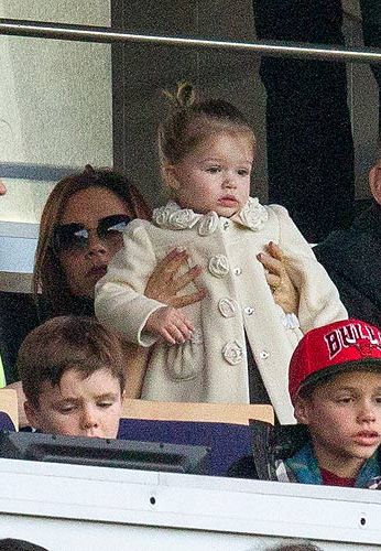<p>What does Harper Beckham wear to a football match? Certainly not a garish footy shirt, that's for sure. Harper watched daddy's Paris Saint-Germain game wearing this cream coat – it must be new because we haven't seen it before. The rose details on the collar and buttons are tres cute. Harper stays true to what we know her for, by wearing a grey dress underneath.</p>