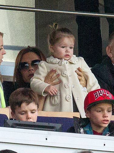 <p>What does Harper Beckham wear to a football match? Certainly not a garish footy shirt, that's for sure. Harper watched daddy's Paris Saint-Germain game wearing this cream coat – it must be new because we haven't seen it before. The rose details on the collar and buttons are tres cute. Harper stays true to what we know her for, by wearing a grey dress underneath.</p>