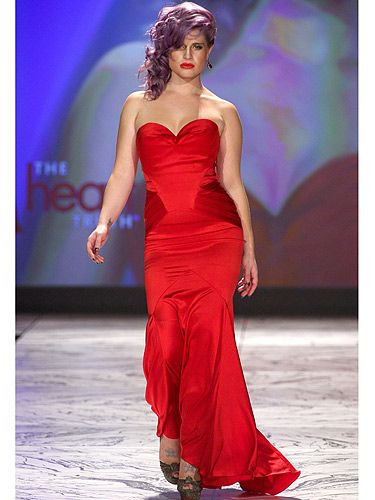 <p>Kelly Osbourne looked red hot at The Heart Truth 2013 Fashion Show held at the Hammerstein Ballroom in New York. The E! babe wore a red L Spoke dress on the catwalk which she teamed with her violet hair colour and a pout to rival a Victoria's Secret supermodel.</p>