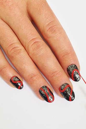 <p>Take a striping brush dipped in red nail polish and paint on a "S" shaped squiggly line from cuticle to tip. Paint on different shaped curved red outlines on the rest of the nails, some from tip to cuticle others from side to side.</p>