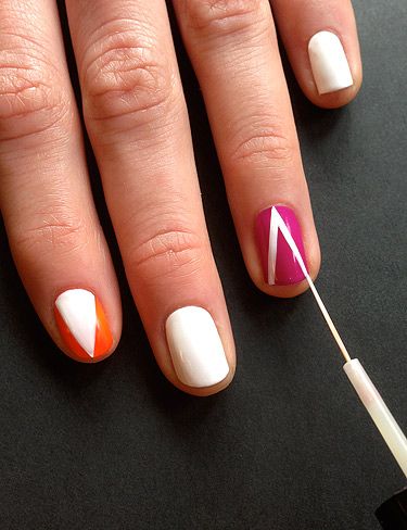 <p>On the orange and purple painted nails paint on a triangle with the striping brush in white polish. Vary the direction of the triangle on each nail, so, place one triangle pointing towards the tip on one nail and a triangle pointing to the cuticle on another.</p>
