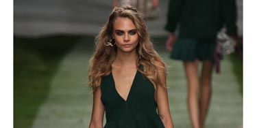 <p>Cara Delevingne's first look - silk printed boxer shorts and a forest green peplum top. </p>
<p> </p>