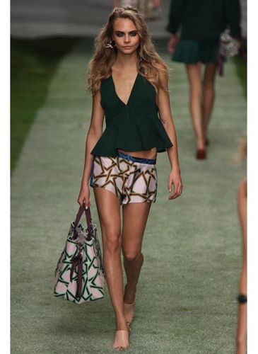 <p>Cara Delevingne's first look - silk printed boxer shorts and a forest green peplum top. </p>
<p> </p>