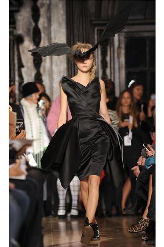 <p>Cara looked striking in all black and a vast 3D headpiece (in the shape of a bat no less) at the Giles Deacon show on Monday. We love the look - and that it was paired with flats!</p>