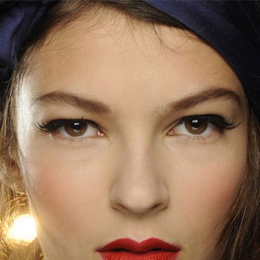 <p><strong>The makeup look:</strong> "A 1950s pin-up beauty…think Dita Von Teese, but in a naughty way, a pin-up that danced to much and is back from the party" said Makeup Artist Carole Colombani using MAC.</p>
<p><strong>The products:</strong> Face - Pinch Me Powder Blush blended over the centre of cheeks for a healthy flush. Eyes - Veluxe Brow Liner used to define the brows in a "retro" way: Perfected two-thirds of the way starting at the inner brow, then sketched in a broken line after the arch before being brushed upwards, lifting the brow. Blacktrack Fluidline drawn through the upper lashline starting at the extreme inner corner and extending outwards to lift and elongate eyes. False Lash Black Mascara blended through the upper lashes only to lengthen and define. 20 Lash half-demis applied above the outer corners of lashes to extend and lift eyes with a beautiful flick. Lips - MAC PRO Crimson and Red Lipmix mixed together for intensity. MAC PRO Basic Red Chromagraphic Pencil used to define, creating a slightly bigger and fuller lower lip to finish.</p>