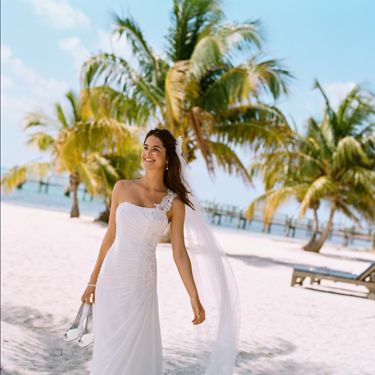 <p>Think about the setting and location of your wedding and try to choose a dress that fits in with the overall theme. if you're planning on a beach wedding, then a softer look or less structured style might go down better in Hawaii, rather than a traditional gown which would suit a church much better.</p>
<p><em>V3398, David's Bridal Collection, Soft White, £475.00, <a href="http://www.davidsbridal.co.uk" target="_blank">davidsbridal.co.uk</a></em><strong> </strong><strong></strong></p>