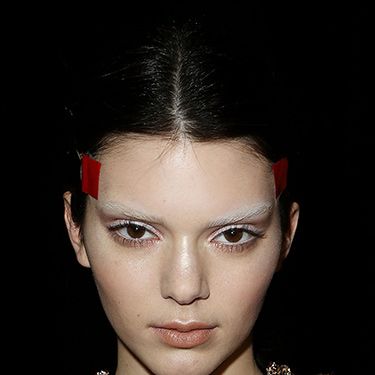 <p><strong>The look:</strong> Models including Kendall Jenner (pictured) had their brows bleached by the legendary Pat McGrath who then contoured the skin in varying neutral shades. To get a feline shape with their eyes, hairstylist Luigi Murenu tightly taped string from the temples around the back of the head and created knotted plaits below.</p>