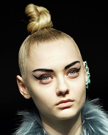 <p><strong>The look:</strong> Tightly coiled topknots paired with severe eyebrows and ultra-winged black eyeliner flicks. There's nothing soft about this look other than the nude lip.</p>